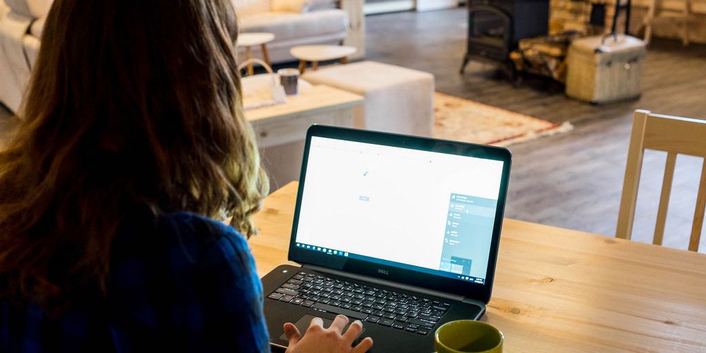 person using laptop in a coffee shop with a VPN