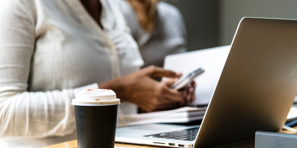 person using laptop with VPN in a coffee shop